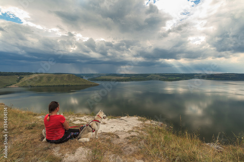 Woman on the shore with two dogs