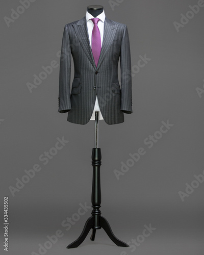 Atelier to repair clothes, Stylish look, Fashion look, Men look, Wedding style, Fashion concept, Brand clothing, Classic costume,Suit on grey background. Store display. Classic style.