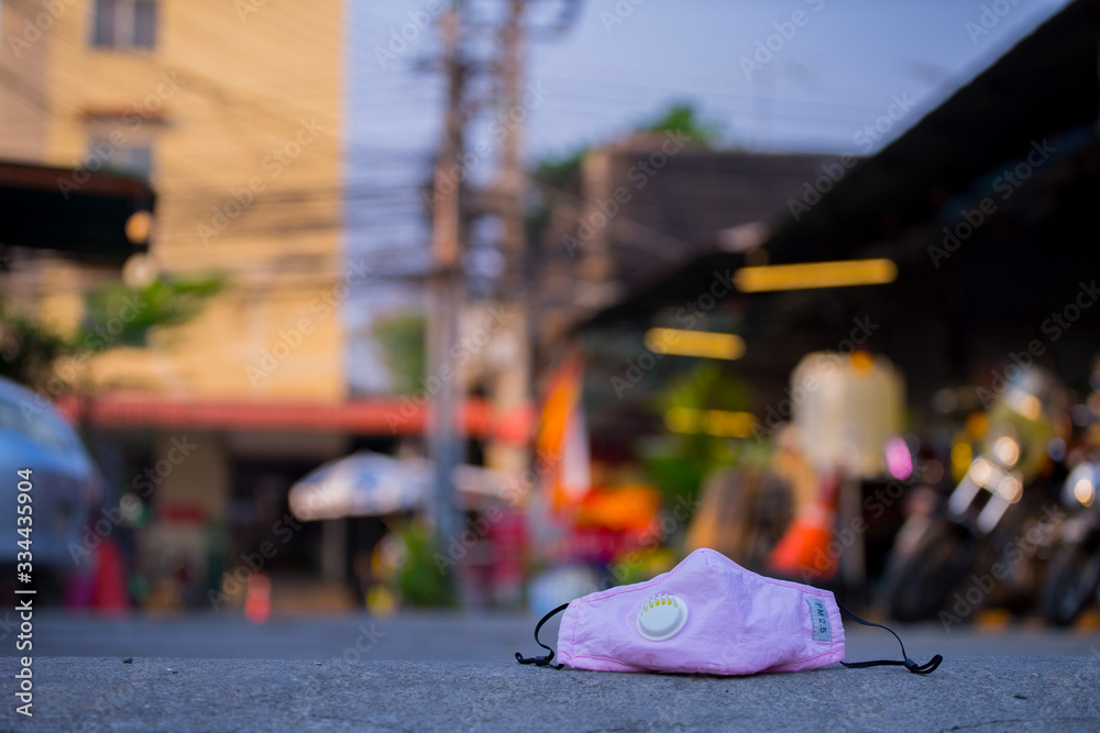 Obraz premium Used mask on ground road, city background,concept for Coronavirus, Covit-19 prevention and disinfection.