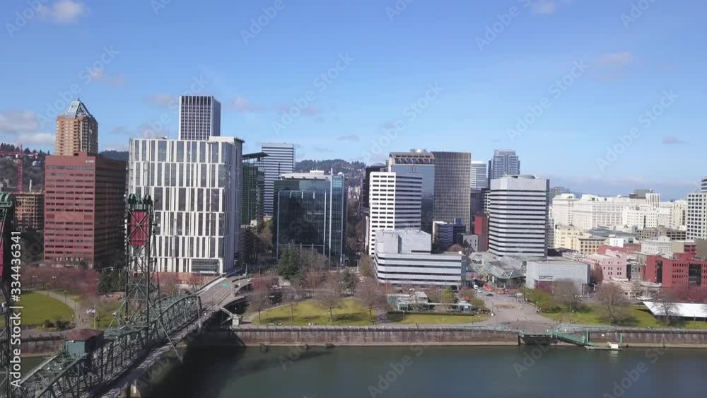 Aerial backwards flying drone shot of Portland Oregon urban city skyline on a sunny morning in Spring. Aerial backwards flying drone shot of Portland Oregon urban city skyline on a sunny morning in Spring.