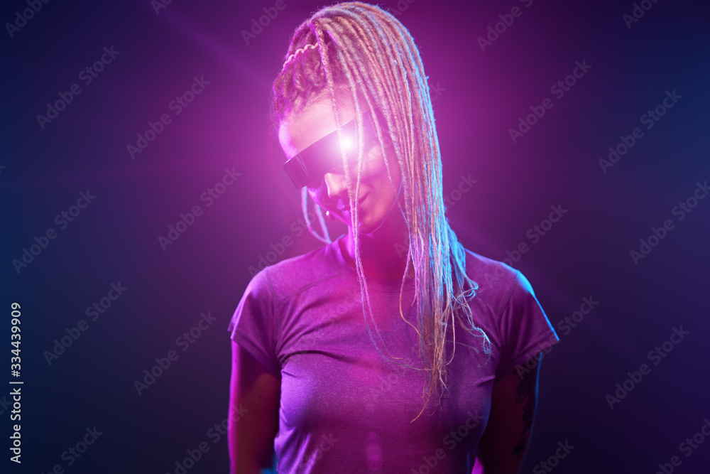 Young girl in sunglasses looking at camera in neon light Young girl in sunglasses looking at camera in neon light