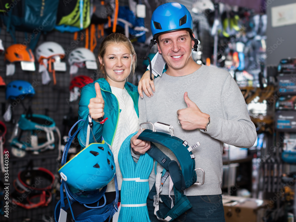 Young couple in sports shop choosing sports equipment