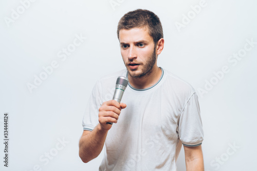 Boy Rocking Out. Image of a handsome man singing to the microphone. Emotional portrait of an attractive guy