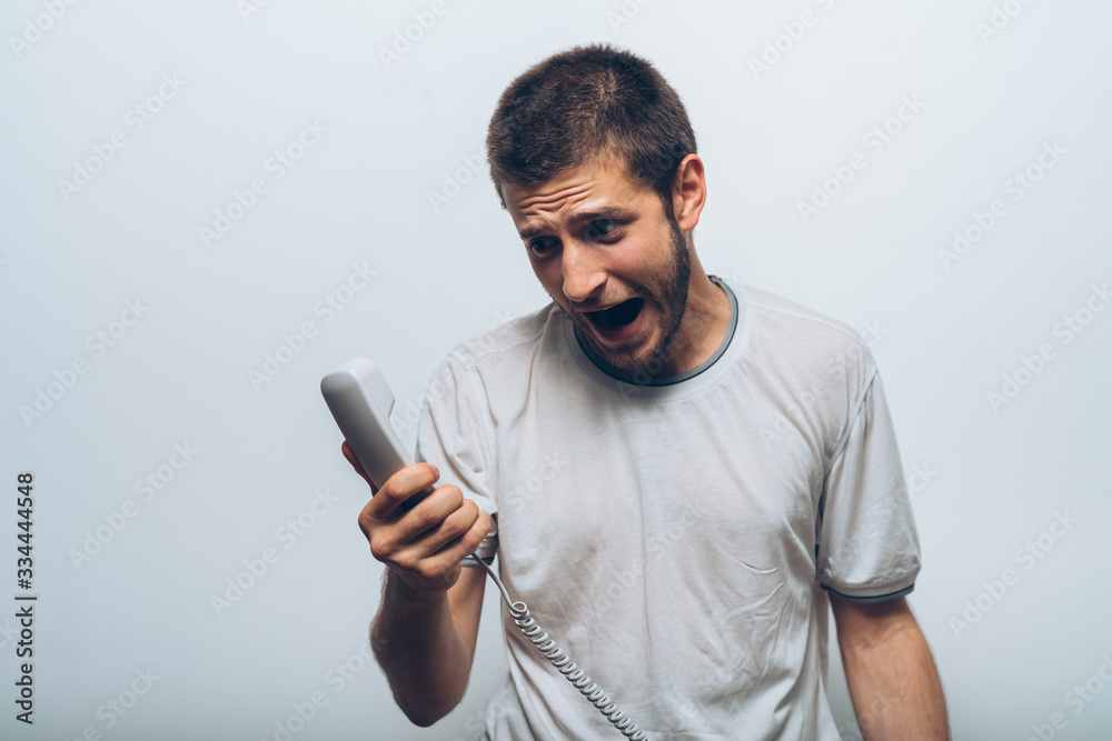 Close up image of a man screaming on the telephone during the conversation. Close up image of a man screaming on the telephone during the conversation.