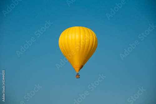 Yellow hot-air balloon against the blue sky. Background. Air balloon flight. Space for text.