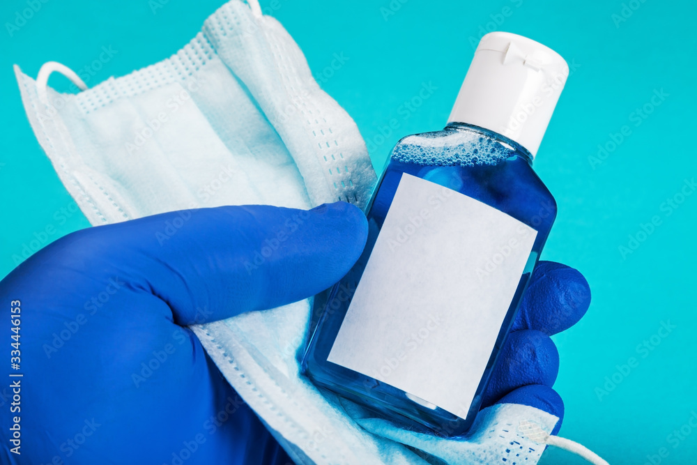 hand in rubber gloves holds personal protective equipment against covid