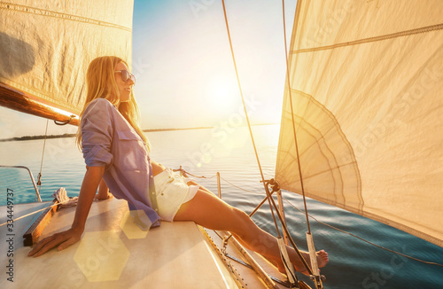 Young happy woman enjoying sunset from deck of sailing boat movi