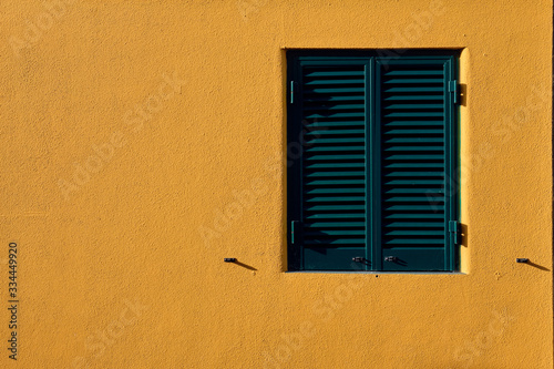 Wooden window on  orange wall.