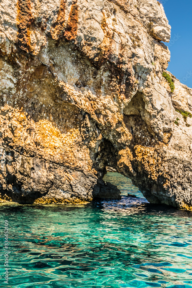 Whole in a cliff along the coast at the amazing blue caves of northern Zakynthos