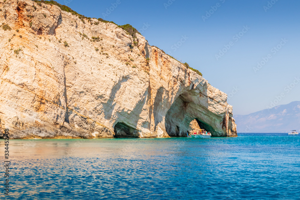 Boats passing through an arched cliff near the Blue Caves on Zakynthos