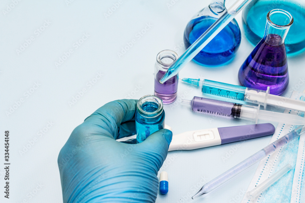 Fototapeta premium Female hand holds a test tube. Laboratory studies of coronavirus. Worldwide pandemic COVID-19, 2019-nCoV, SARS-CoV-2