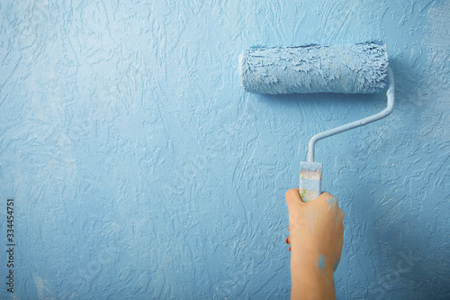 Fototapeta Naklejka Na Ścianę i Meble -  Idea for home interior. Girl paints wall in blue