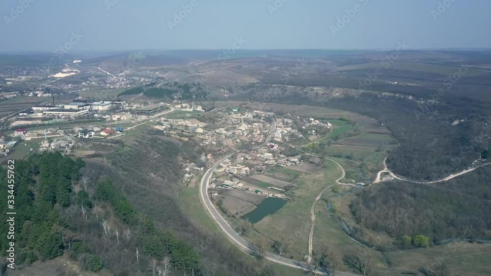 drone flying above european small village surrounded by hills and forests. Early spring. Moldova republic of. drone flying above european small village surrounded by hills and forests. Early spring. Moldova republic of.