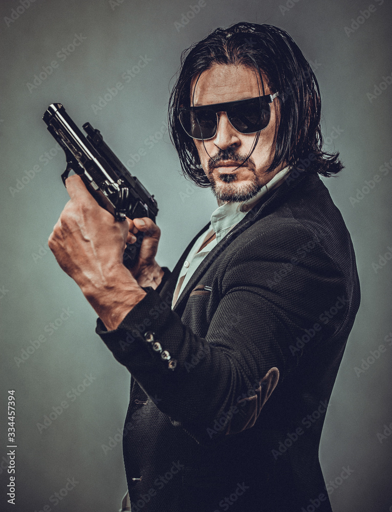 sexy muscular body model portrait of a young man holding a gun in his hands sexy muscular body model portrait of a young man holding a gun in his hands