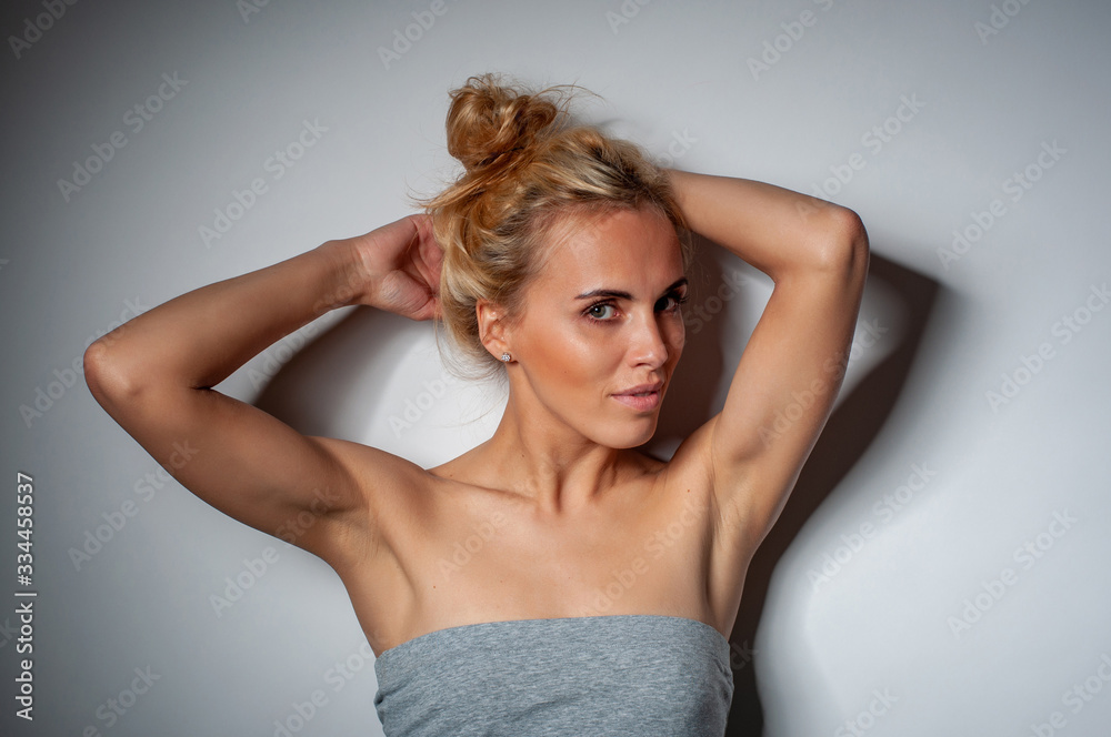 horizontal portrait of a beautiful blonde in a summer gray dress with bare shoulders