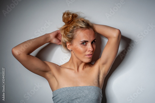 horizontal portrait of a beautiful blonde in a summer gray dress with bare shoulders