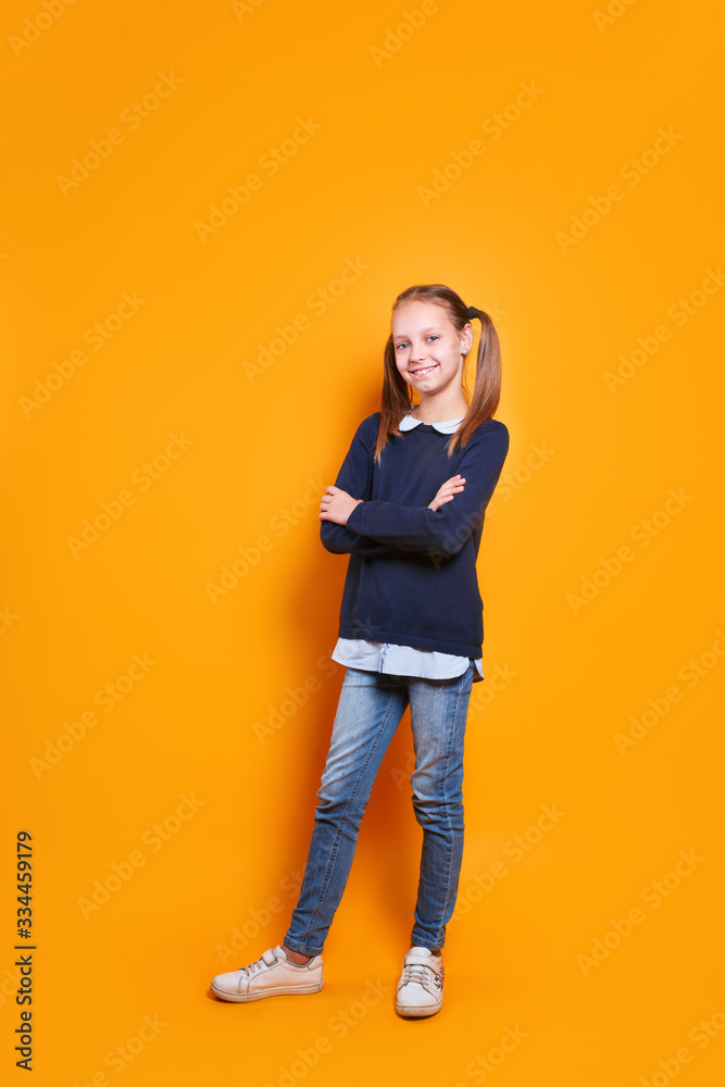 funny happy little girl in casual clothes standing on yellow studio background funny happy little girl in casual clothes standing on yellow studio background