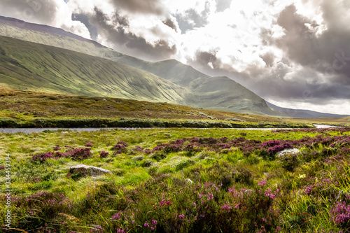 Spectacular bright landscape of the incredible mountains and a river of the Scottish Highlands in the summer.