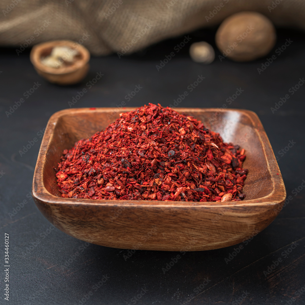 spices seasonings and grains on a square wooden bowl on a dark background and burlap spices seasonings and grains on a square wooden bowl on a dark background and burlap