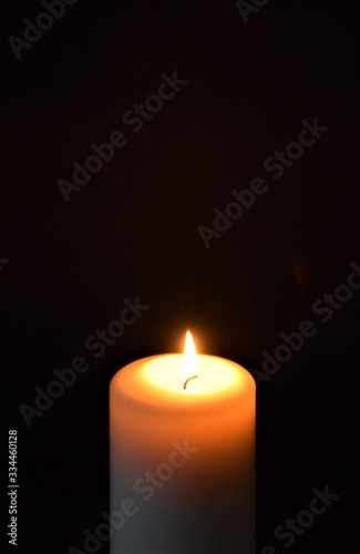 Burning candle closeup with black background