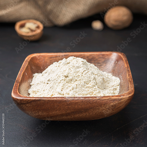 spices seasonings and grains on a square wooden bowl on a dark background and burlap