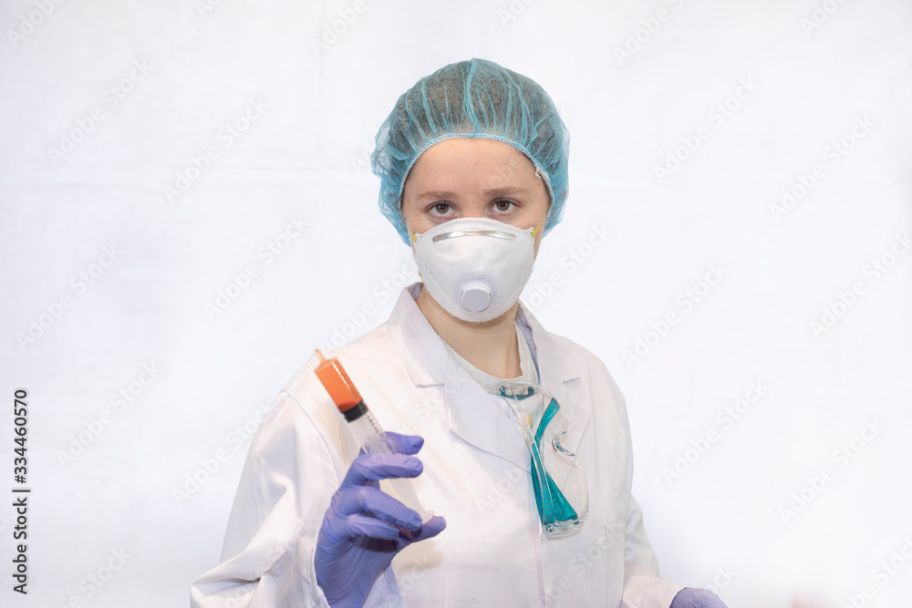 nurse or doctor with her protective equipment on with a syringe in her hand