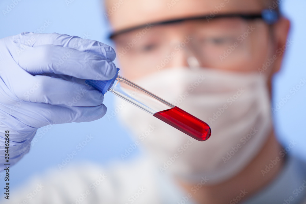 Lab. A lab technician in a white coat, rubber gloves and protective glasses checks the behavior of the substance in a closed environment. Lab. A lab technician in a white coat, rubber gloves and protective glasses checks the behavior of the substance in a closed environment.