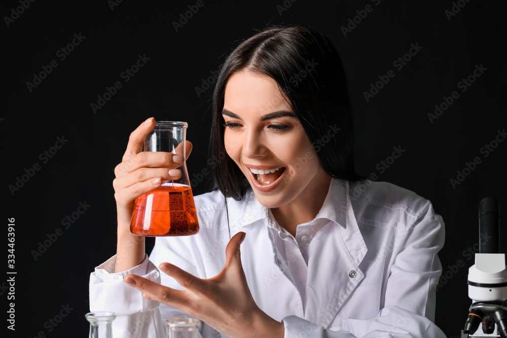 Crazy female alchemist with potion on dark background Crazy female alchemist with potion on dark background