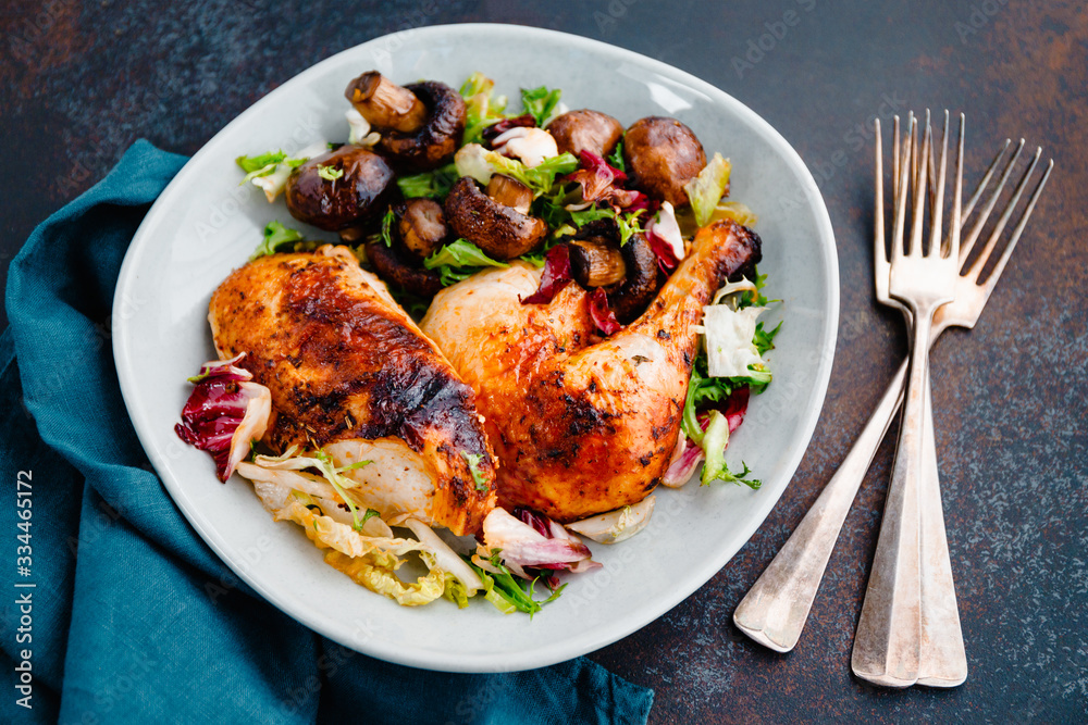 Roasted chicken leg and breast with fresh salad and champignons on a plate. Roasted chicken leg and breast with fresh salad and champignons on a plate.
