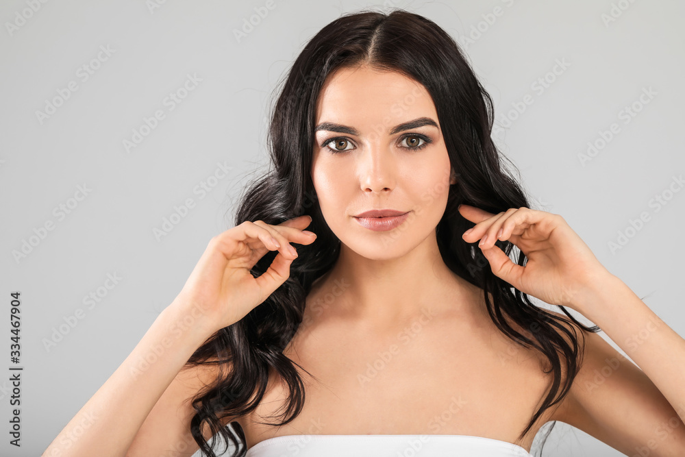 Young woman with beautiful healthy hair on grey background Young woman with beautiful healthy hair on grey background