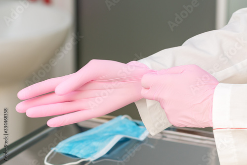 Doctor puts on gloves.