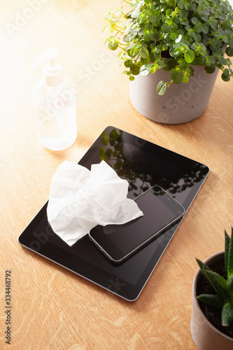 disinfecting tablet computer and smartphone screen, eliminating germs coronavirus bacteria photo