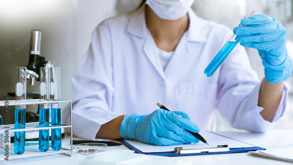 Fototapeta premium Scientist wear lab coat and protective wear are working with research or doing investigations with test tubes in experiment, Laboratory and development concept