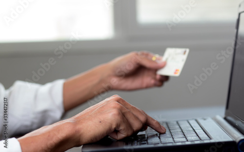 Young man typing on laptop with holding credit card, Payment online shopping concept