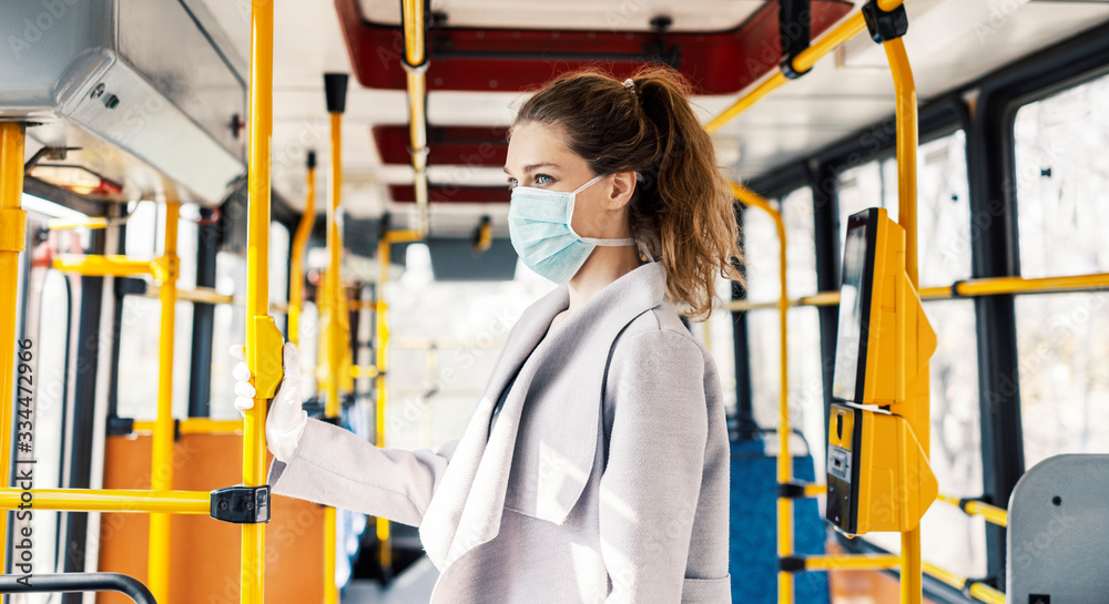 Woman wearing surgical protective mask in a public transportation - obrazy, fototapety, plakaty 