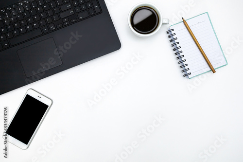 Office desktop with accessories and white coffee cup on white table. Top view. Business background.