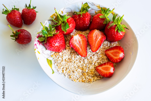 tasty oatmeal with strawberries on white table