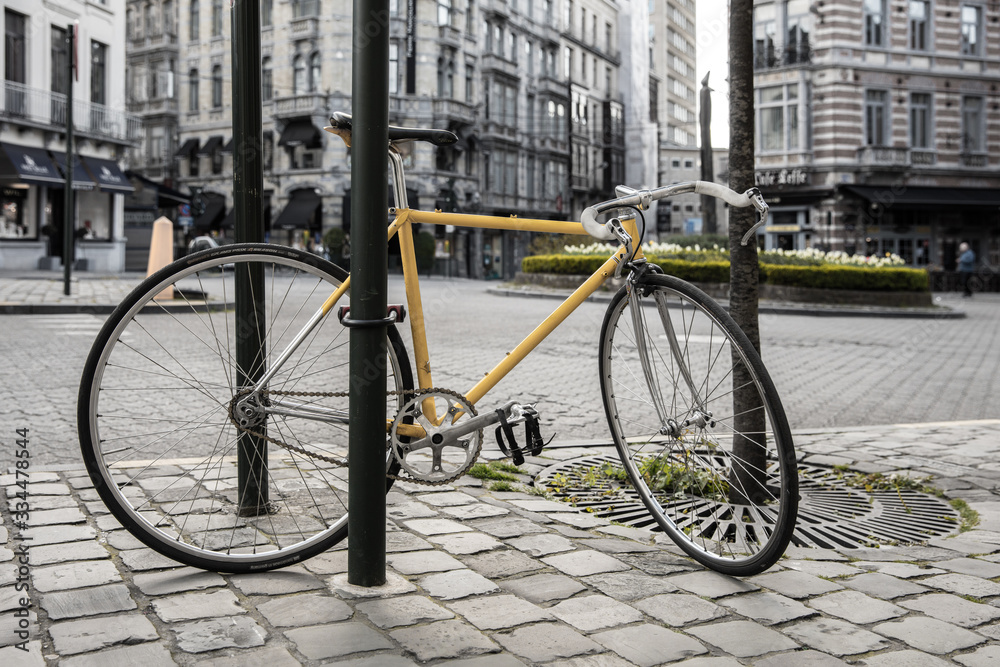 Vintage Racebike locked at metal pole in urban environment
