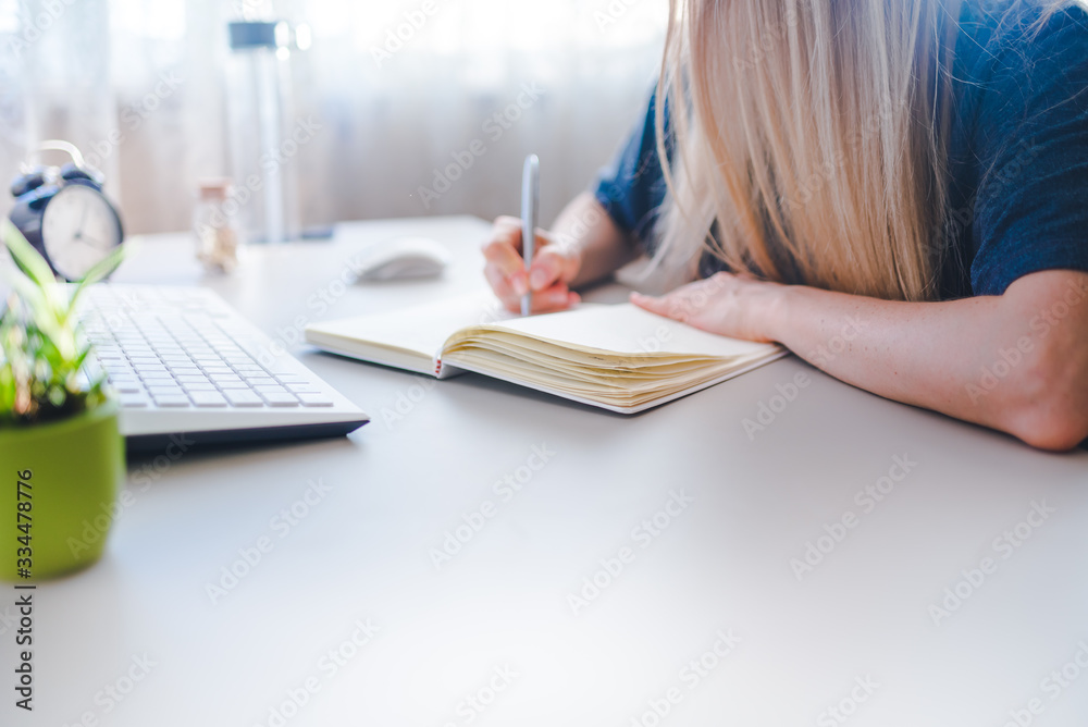 girl writes in a notebook, draws up a schedule for the week girl writes in a notebook, draws up a schedule for the week