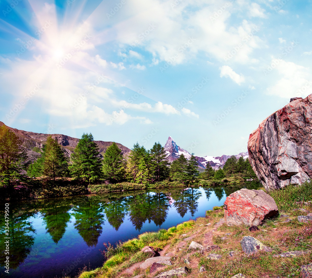 Magical beautiful landscape with a big rock near the lake and fir trees on background Matterhorn in the Swiss Alps, near Zermatt, Switzerland. Amazing places. (Meditation, antistress - concept).