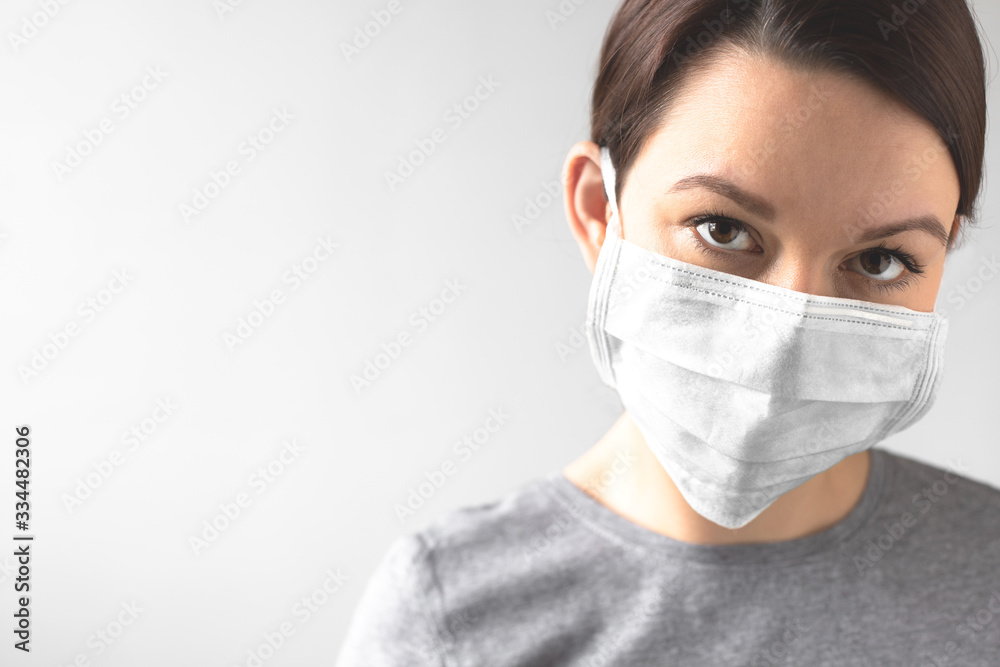 Coronavirus concept. Girl wearing a protective medical mask. Protect your health. Stop the virus and pandemic covid-19. Light gray background Coronavirus concept. Girl wearing a protective medical mask. Protect your health. Stop the virus and pandemic covid-19. Light gray background