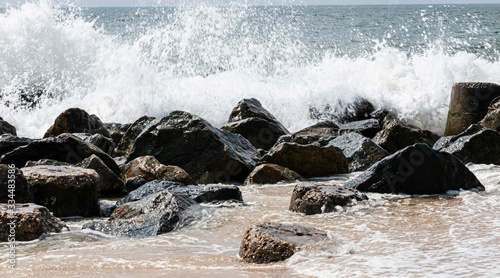 Photo Ocean waves crashing on a jetty of rocks on the beach