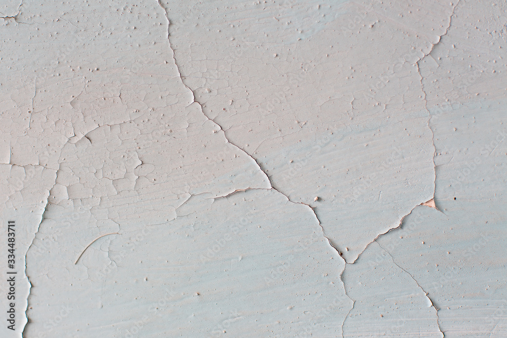 Obraz premium Wall with cracked white paint. Texture of old peeling paint, vintage background, cracked paint, old paint, traces of beige paint.