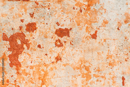 Old orange paint peels off the wall. Grunge rough wall texture background. Exfoliating surface paint, exfoliating orange and red.