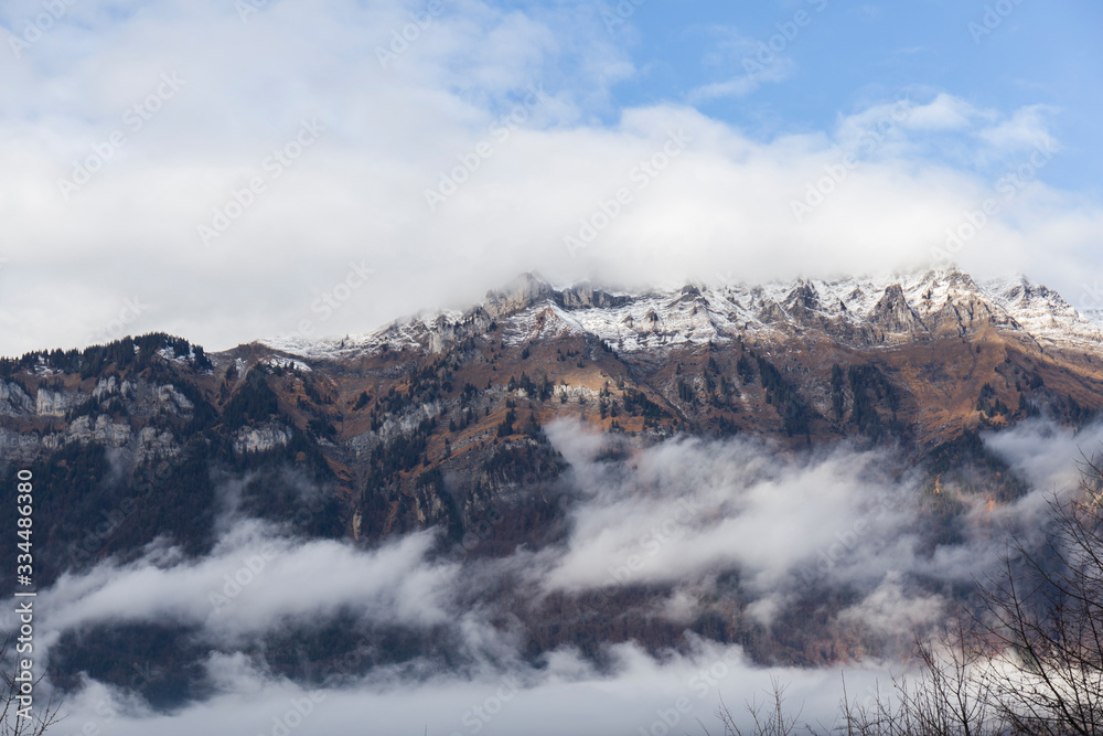 landscape of some snowy mountains among the low clouds
