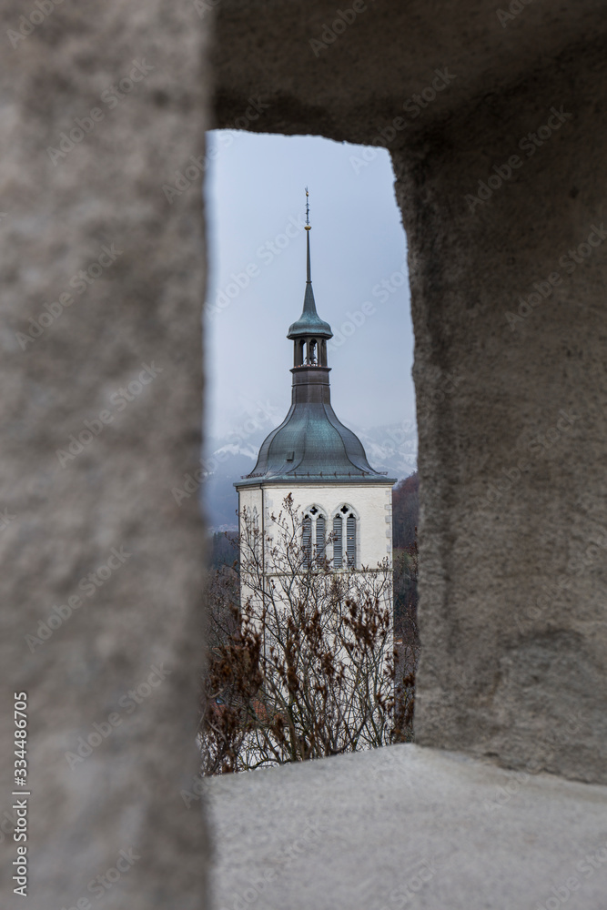 through a stone arch we can see part of a church in a mountain village through a stone arch we can see part of a church in a mountain village