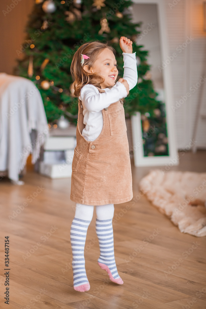 little girl plays near the christmas tree
