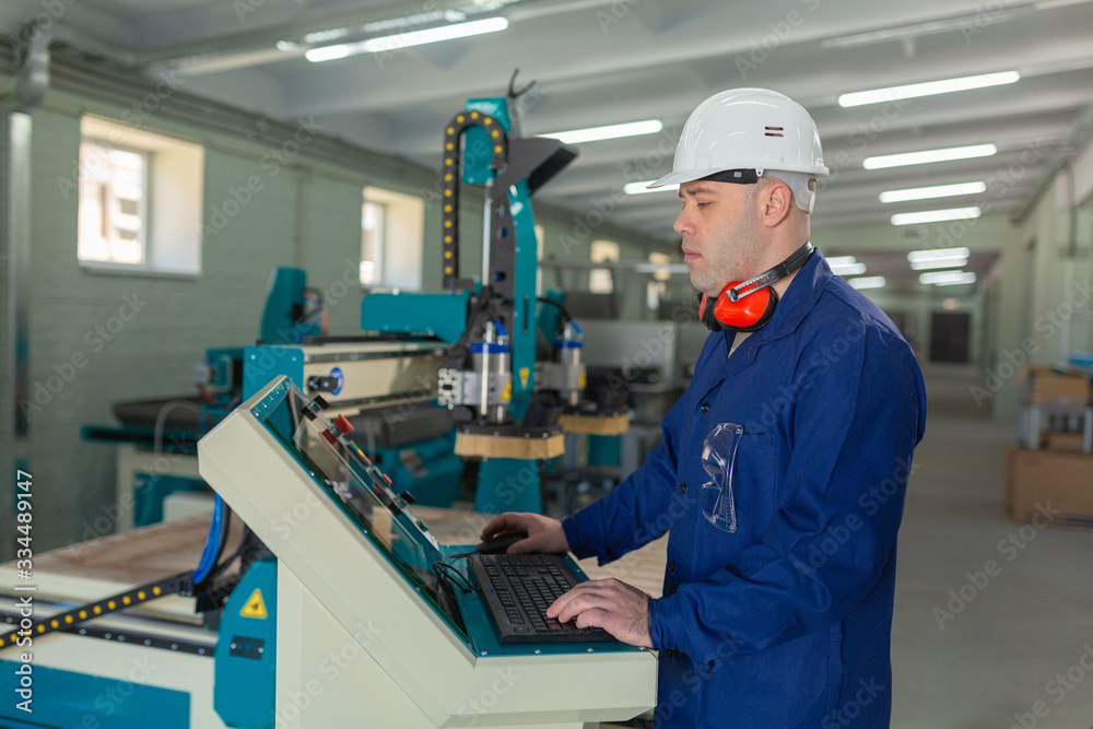 Worker in the Hard Hat Modern Factory CNC machine operator . Successful, Handsome Man in Modern Industrial Environment.Emotions, Copy Space Worker in the Hard Hat Modern Factory CNC machine operator . Successful, Handsome Man in Modern Industrial Environment.Emotions, Copy Space