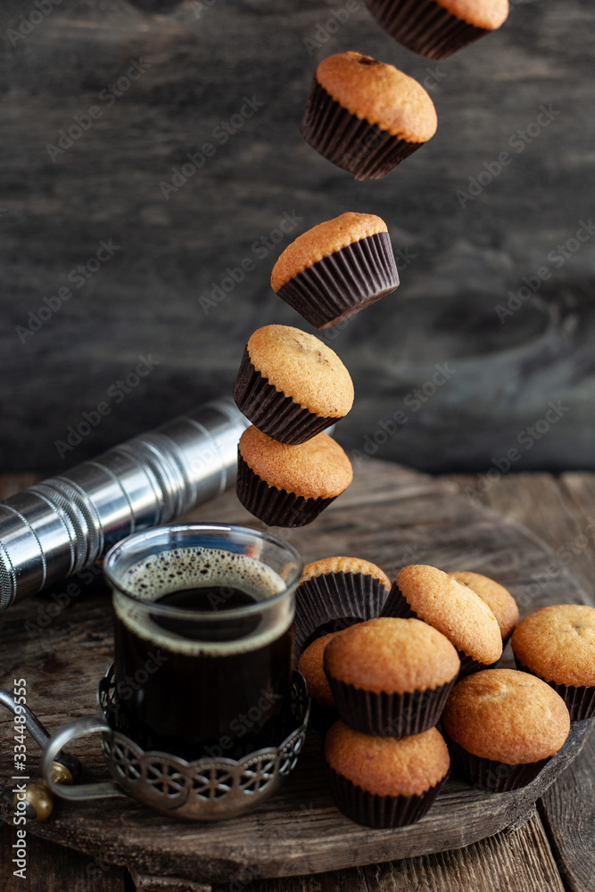 Flying muffins fall into a cup of coffee. Flying food. Flying muffins fall into a cup of coffee. Flying food.