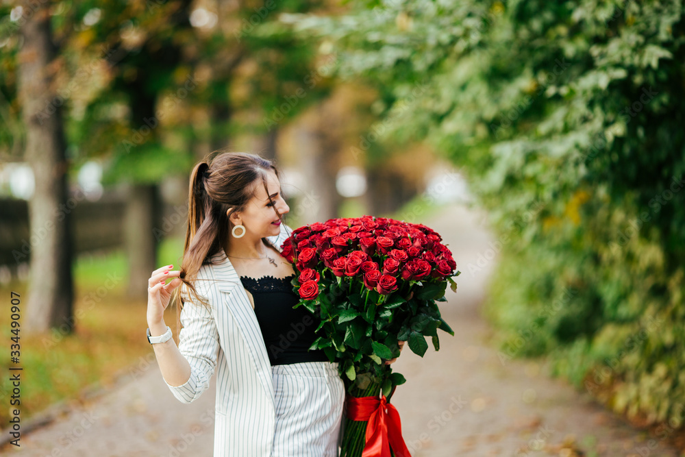 Fototapeta premium Valentines day. Woman holding bouquet of red roses. Beautiful girl received romantic present.